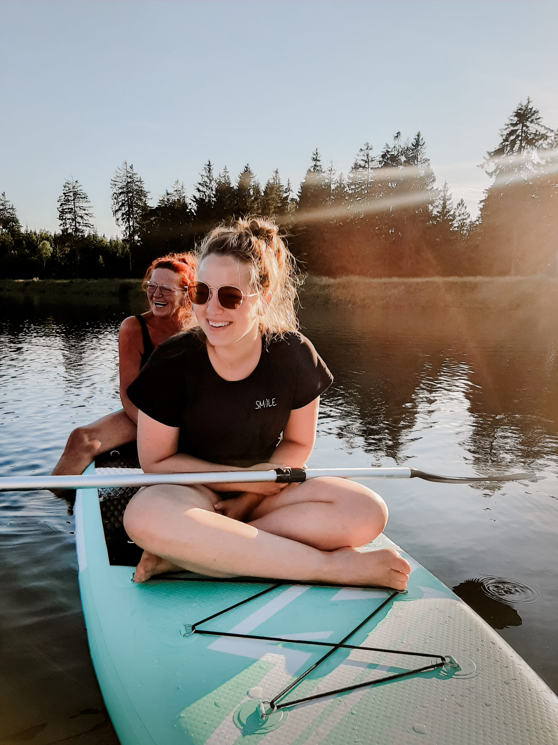 Hochzeitsfotografin Kristina Reinartz sitzt auf einem SUP am Kiefhözer Teich in Clausthal-Zellerfeld im Harz